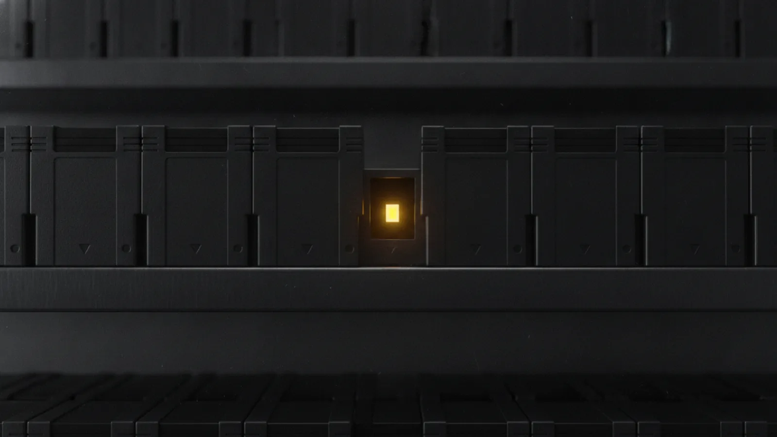 Une rangée de cartouches de jeu rétro identiques sur une étagère sombre, un seul emplacement vide au milieu de la rangée.