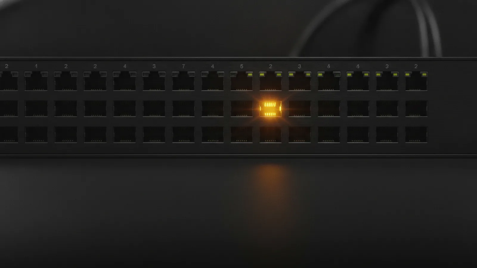 Face avant d’un commutateur réseau sombre percé d’une rangée de ports Ethernet identiques, un seul port allumé en ambre.